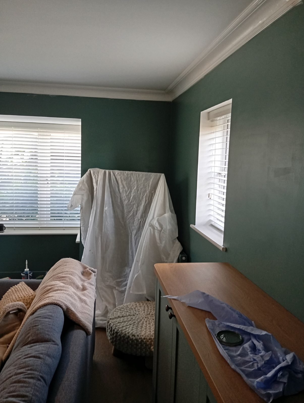 Living room with furniture covered in dust sheets ready for decorating