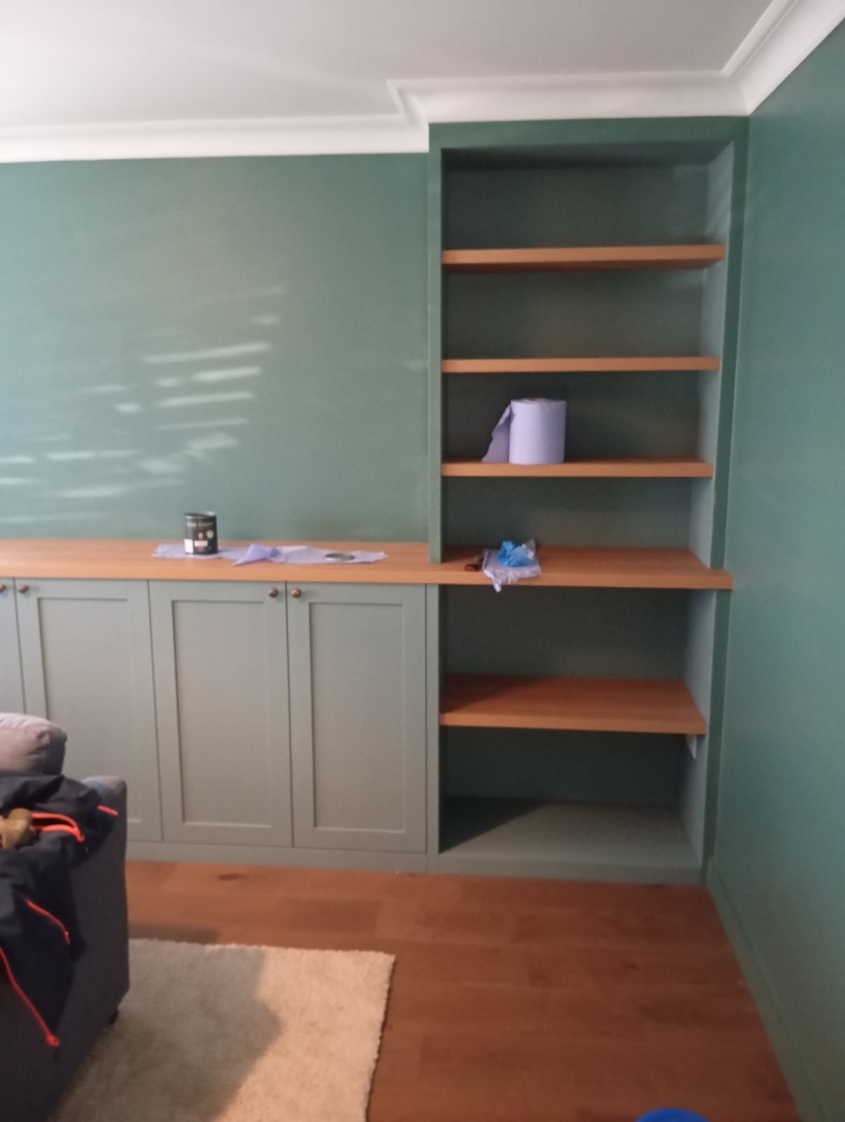 Alcove shelving painted sage green with oak shelves
