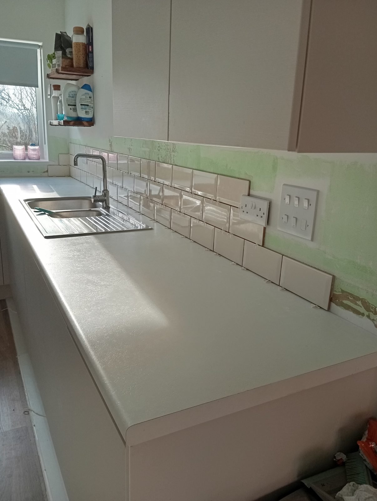 Long run of metro tiles along the worktop towards the sockets